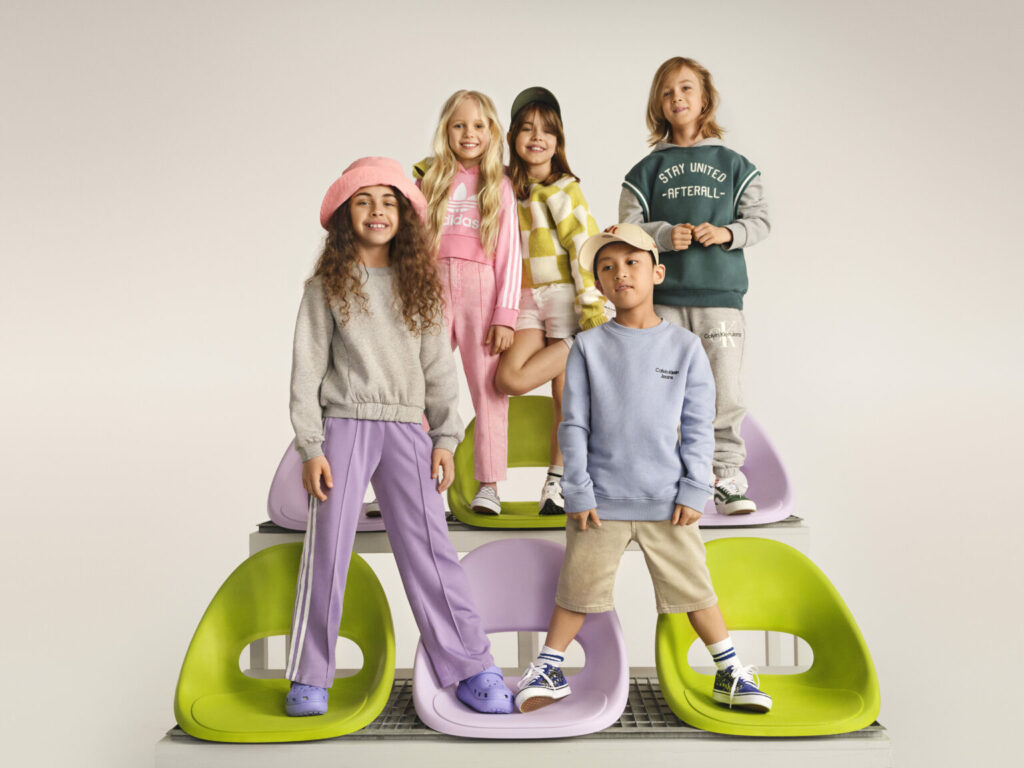5 παιδικά μοντέλα ποζάρουν σε πολύχρωμες καρέκλες