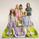 5 παιδικά μοντέλα ποζάρουν σε πολύχρωμες καρέκλες