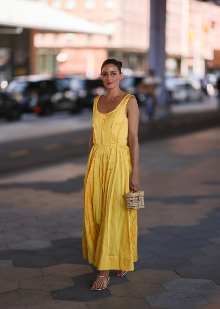 Γυναίκα με κίτρινο μάξι φόρεμα και ασημένια σανδάλια