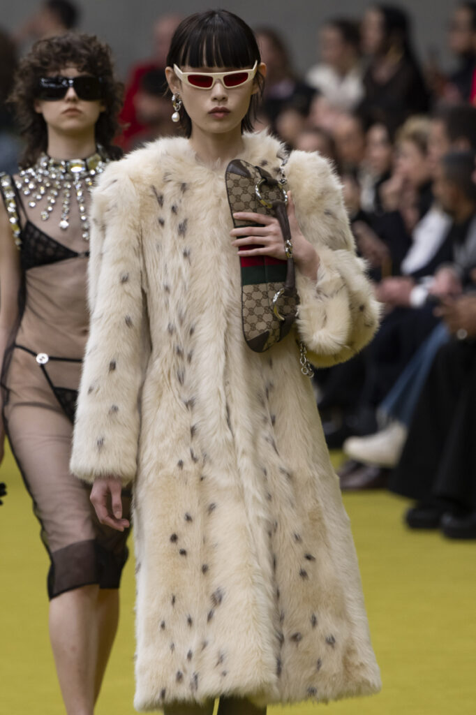μοντέλο στην πασαρέλα με γυναικείο παλτό από τεχνητή γούνα