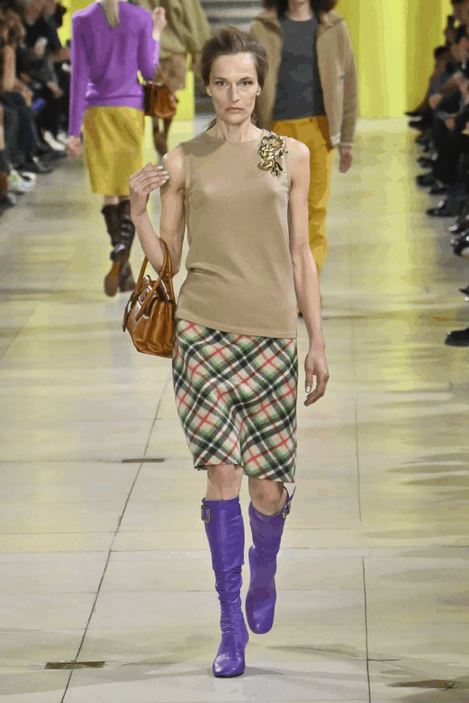 Μοντέλο με πολύχρωμα μπότες, φούστα πένσιλ και εφαρμοστό τοπ Miu Miu – τάσεις φθινόπωρο-χειμώνας 2025/2026: office core και έντονα χρώματα